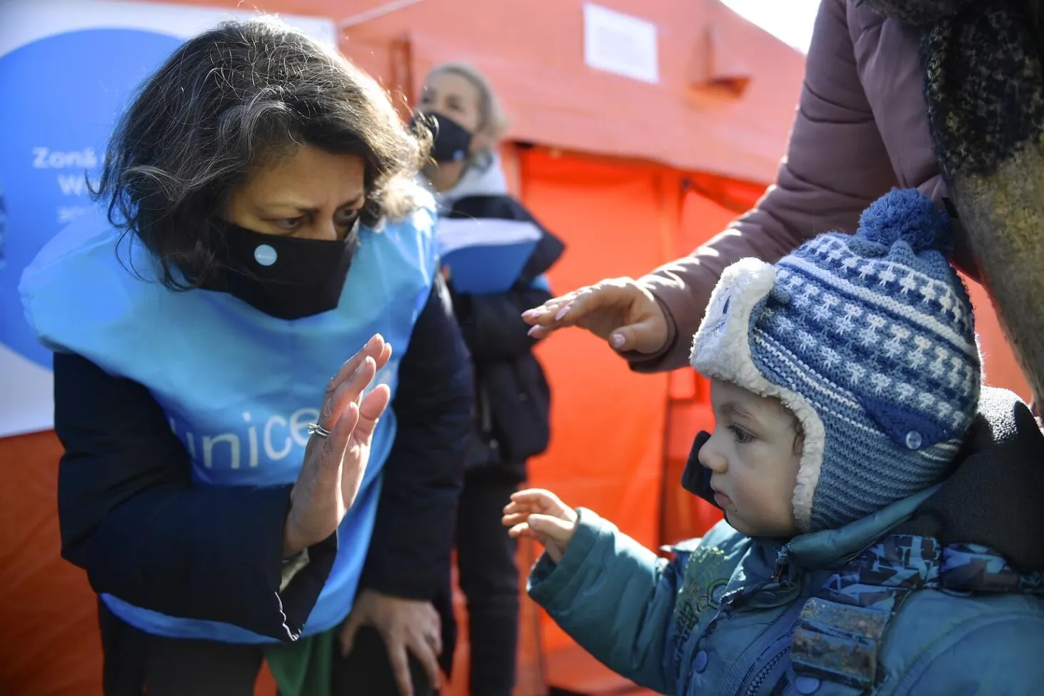 UNICEF staff and boy wave