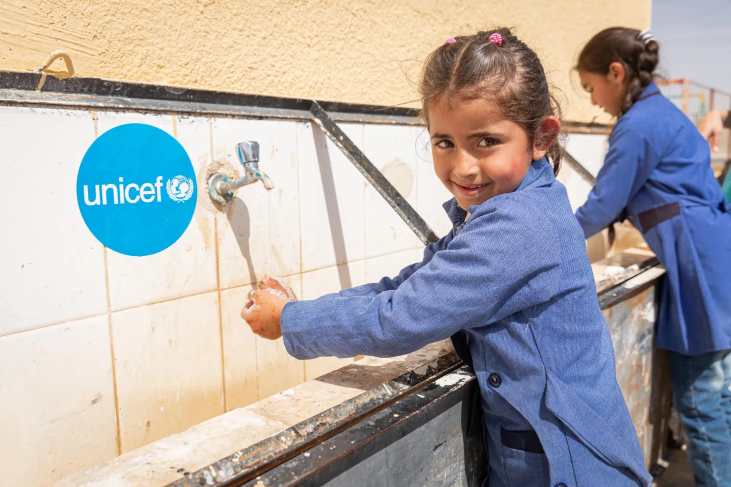 A girl washing her hand at a UNICEF water station
