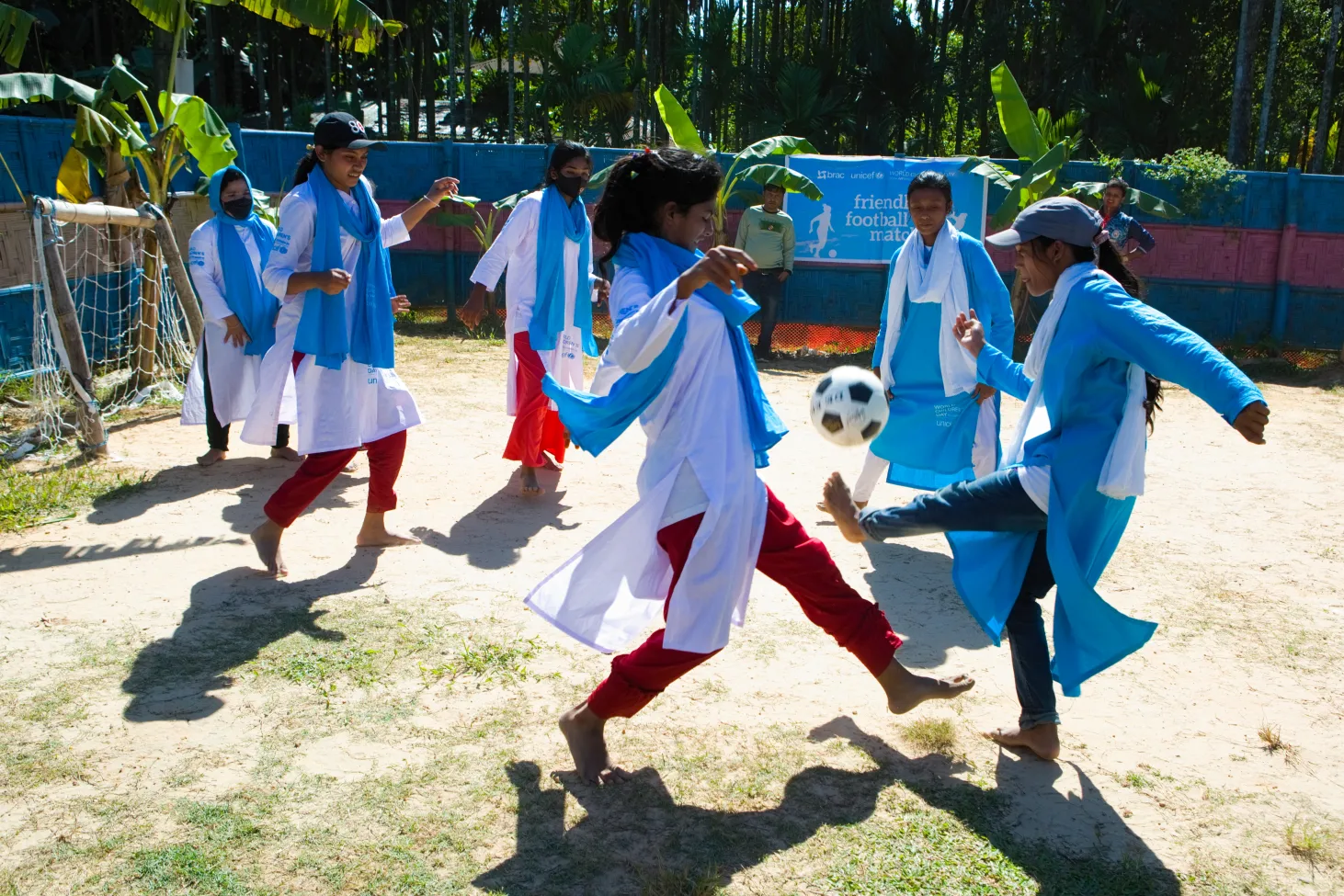 Two girls spar over a soccer ball as their team members look on behind them in a soccer match in Cox's Bazaar, Bangladesh. 