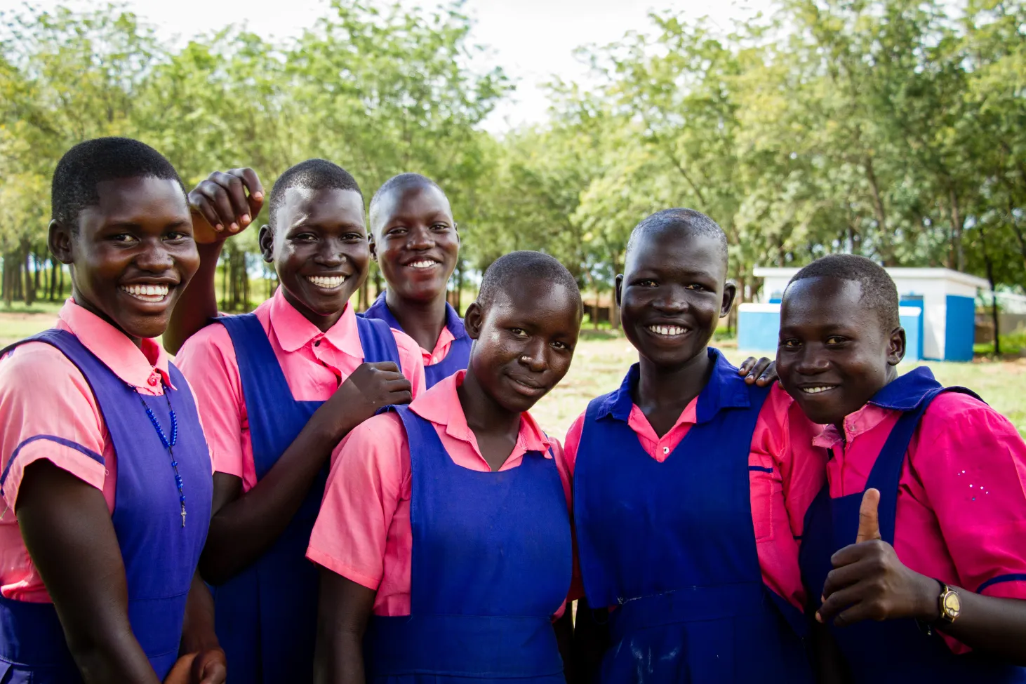 Des étudiantes prennent la pose devant les toilettes financées par UNICEF à l’école primaire Unwia à Adjumani, district du nord-ouest de l’Ouganda.