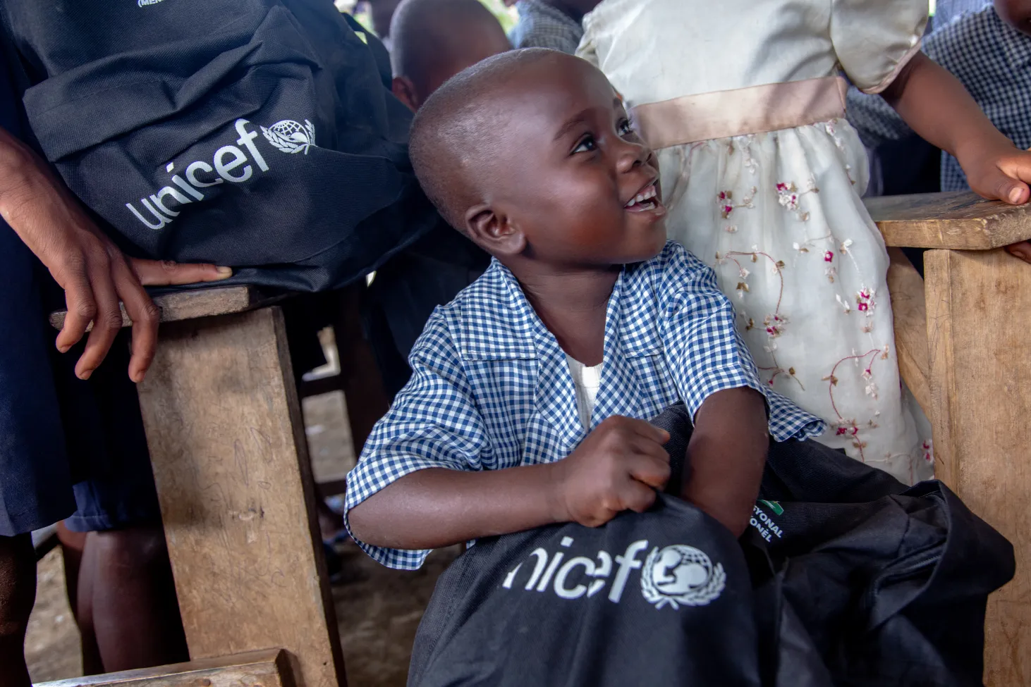 Un enfant de Galette Contonnier arbore un grand sourire lors qu’il a reçu son sac à dos contenant du matériel scolaire.