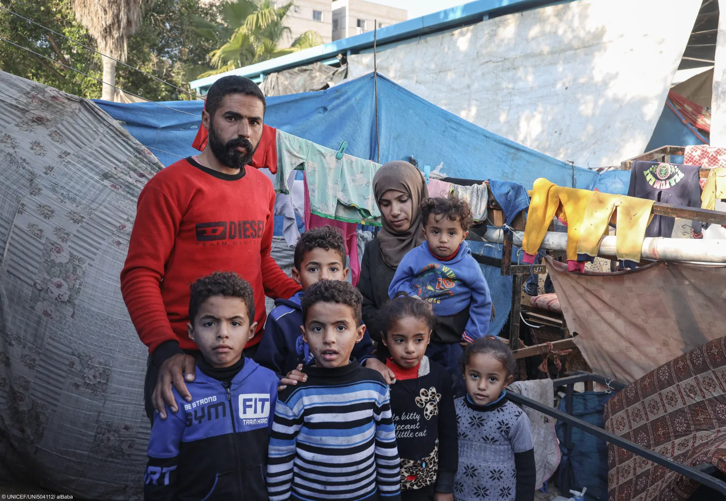 Mahmoud and his wife Eman pose for a photograph with their children: 6-year-old twins Salah and Ameer, front left; 10-year-old Mohammed, back; one and a half years old Yamen, in his mother's arms; 9-year-old Dalia, second right; and 4-year-old Maria, far right