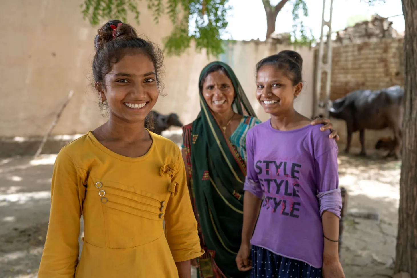 Chez elles dans l’État du Gujarat, en Inde, Sandhya, âgée de 15 ans, Asha, âgée de 17 ans, et leur mère sourient à l’objectif. 