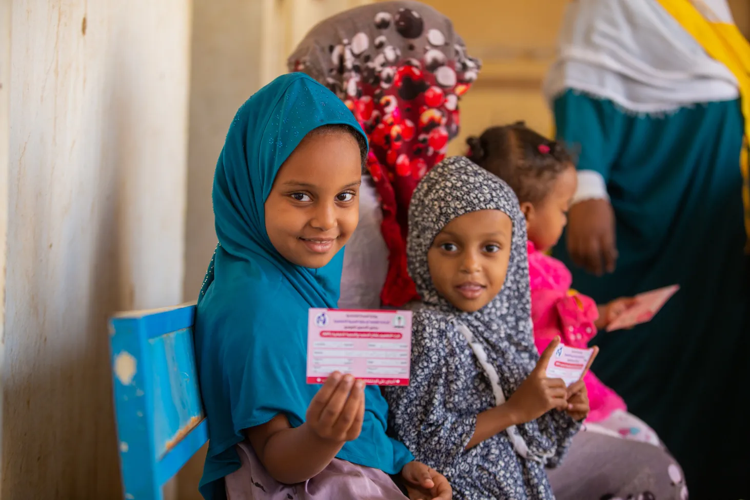 Une petite fille montre sa carte de vaccination après avoir été vaccinée contre la rougeole et la rubéole dans l’État de Kassala, au Soudan.