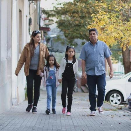 A migrant family walks down a street in Uruguay.