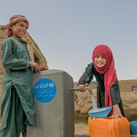On 14th June 2023, a group of children collect water from a tap, installed with UNICEF support, in Ahu Dara village, Sholgara District in Balkh Province, Afghanistan.