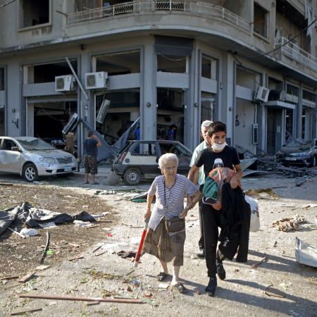 A woman is evacuated from the partially destroyed Beirut neighbourhood of Mar Mikhael on August 5, 2020 in the aftermath of a massive explosion in the Lebanese capital. - Rescuers searched for survivors in Beirut today after a cataclysmic explosion at the port sowed devastation across entire neighbourhoods, killing more than 100 people, wounding thousands and plunging Lebanon deeper into crisis.