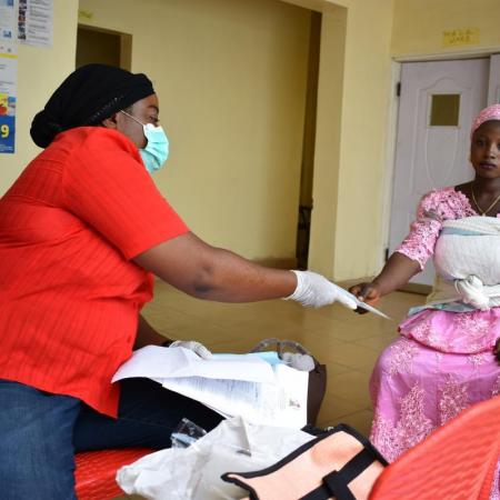 A registrar shows a new mother a birth registration form.