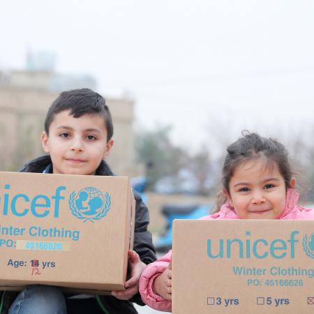 Two children show off their UNICEF supplies in Lebanon.