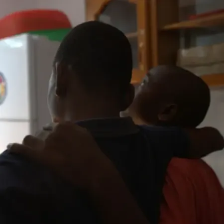 Two children with their backs turned to the camera looking out