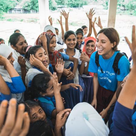 A Louis Vuitton staff member meets with children at a school in Nepal.