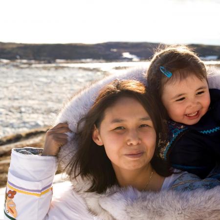 Une mère inuite porte son enfant dans son amauti.