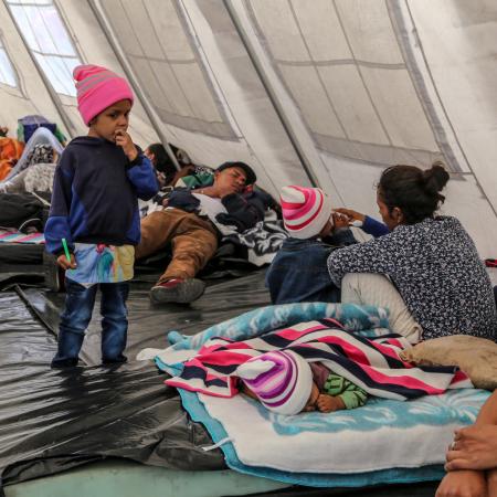 child standing in a UNICEF temporal rest tent in Rumichaca, Ecuador