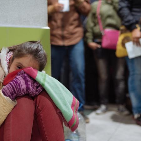 girl waits in line at Colombia Ecuador border