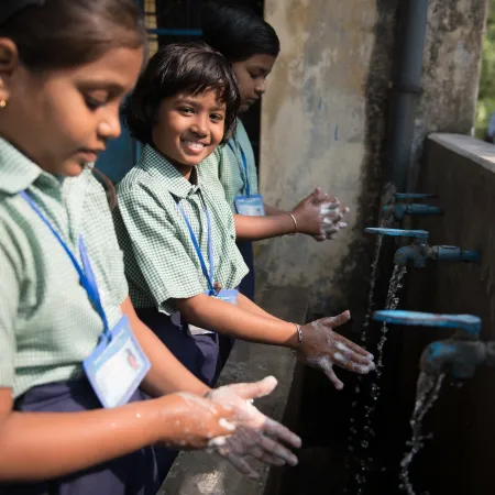 Student wash their hands in India.