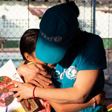 A UNICEF aid worker gives a hug to a Mexican girl.
