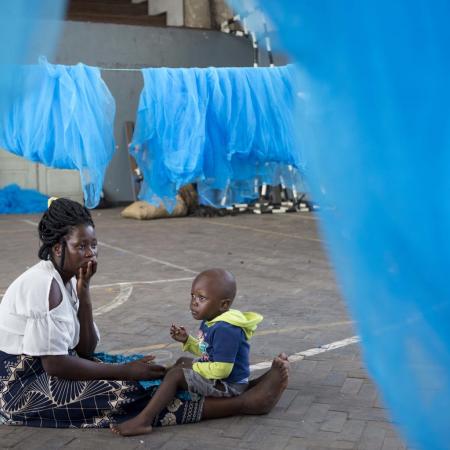 woman and chjld surrounded by mosquito nets