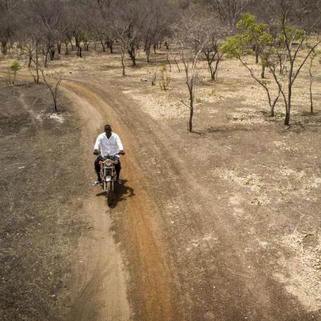 UNICEF staffer Adama rides his motorbike to vaccinate children.