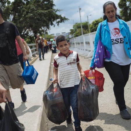 Luisyan Diaz, 7 years old, helps his grandmother and mother cross the border on the Simon Bolivar Bridge in Colombia, from their home in Venezuela.