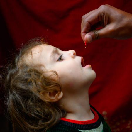 A four year old girl receives Vitamin A form Ajmal, a polio vaccinator in Lahore during Pakistan's first national campaign of the year, aiming to vaccinate over 40 million children under five year of age against polio and provide Vitamin A supplementation.