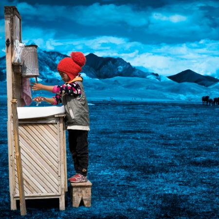 A child washes their hands at a portable station in Mongolia.