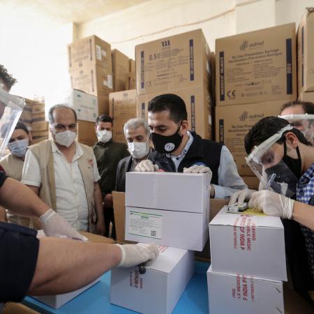 On 21 April 2021, staff members of UNICEF and WHO togerther with local partners, inspect the first shipment of COVID-19 vaccines for the COVAX Facility in Jdaydet Yabous, a village situated on the border between Syria and Lebanon, in the rural area of Damascus.