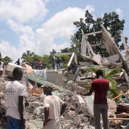 Les gens fouillent les décombres de ce qui était l'hôtel Manguier après le tremblement de terre en Haïti.