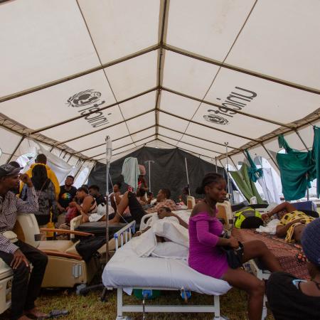 On 17 August 2021, patients of Ofatma Hospital in Les Cayes, Haiti and their families wait for medical attention in a UNICEF-supplied tent in the hospital's courtyard. UNICEF installed the tents to shelter patients who feared the hospital building could collapse.