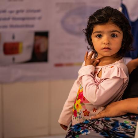 two-year-old Fatima, waits her turn for health and nutrition screening at Bab-e-Bargh health centre where UNICEF-supported immunization, health, nutrition and ante/post-natal care continue to be provided in Herat city’s largest health clinic.