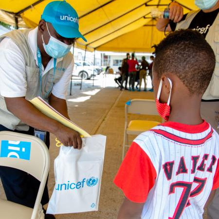 Marc receiving an education kit from UNICEF staff at the Port au Prince airport upon his arrival in Haiti.23 September 2021 – Port au Prince Airport, Haiti. Haitian families being expelled from the United States border to Haiti through several flights during the day.  UNICEF is on the ground at the airport and provides returning children with psychosocial support, protection services and education supplies, in coordination with national authorities and the International Organization for Migration.  