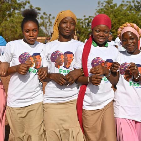 5 young girls stand with arms locked, looking at the camera in Ouahigouya, in the North of Burkina Faso.