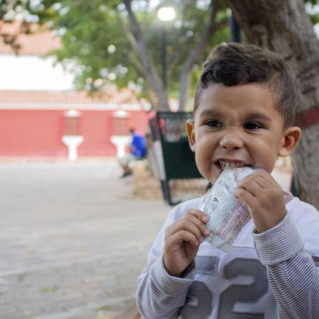 Un enfant mange le contenu d’un sachet d’aliment thérapeutique prêt à l’emploi au Venezuela.