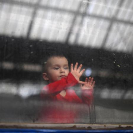 A child looks out from a carriage window