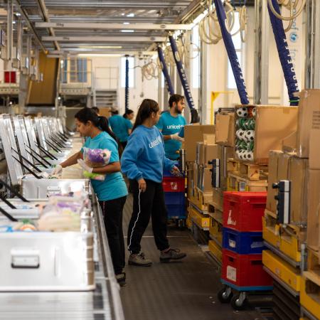 UNICEF workers and volunteers pack boxes for shipping. 