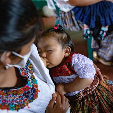 A woman breastfeeds a child.