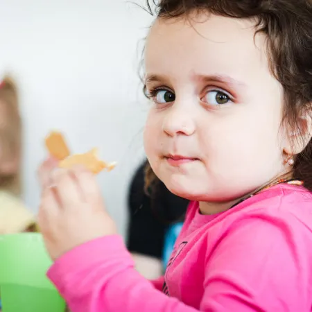 A child enjoys their lunch in school cafeteria