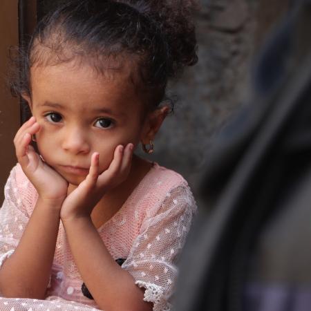 Une petite fille attend de recevoir des fournitures d’urgence au Yémen.