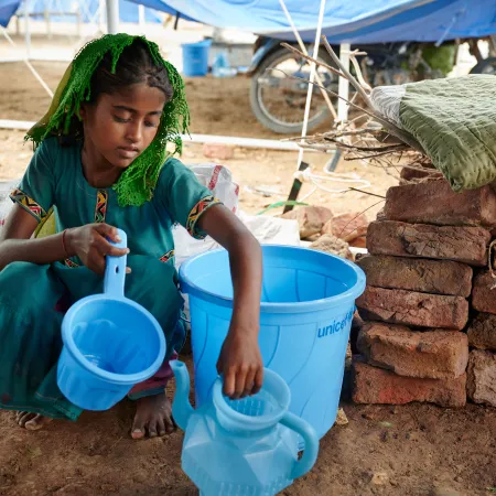 On 14 September 2022, sitting on floor of her shared tent, Geetu, 8 years old, shows off a hygiene kit her family received from UNICEF at Mohammad Medical Emergency Camp in Umerkot District, Sindh Province, Pakistan.