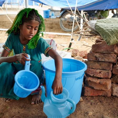 On 14 September 2022, sitting on floor of her shared tent, Geetu, 8 years old, shows off a hygiene kit her family received from UNICEF at Mohammad Medical Emergency Camp in Umerkot District, Sindh Province, Pakistan.