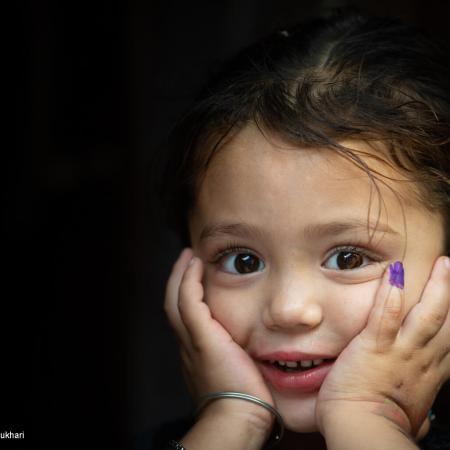 4-year-old Gul-e-Rukh poses for the UNICEF camera, showing her marked finger after receiving the polio vaccine, in Karachi, Pakistan.