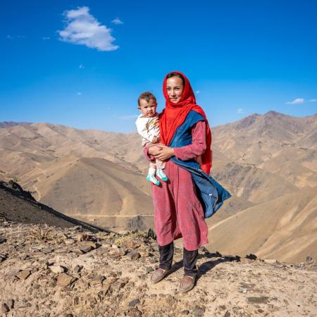 A mother smiles as she holds her child.