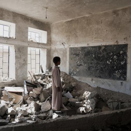 child in destroyed classroom in Yemen