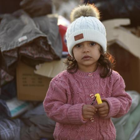 A little girl stands amongst the boxes of supplies sent to the survivors of the 7.7 magnitude earthquake in Kahramanmaraş, Türkiye.