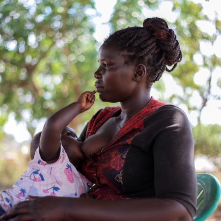 Amal Esther, a Care Group Volunteer from Cluster K, Panyadoli Refugee Settlement in Kiryandongo District breastfeeds her baby Anena on 3 March, 2023.