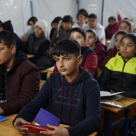 Children attending lessons at a UNICEF-supported tent classroom in a temporary shelter in Antakya, after two devastating earthquakes hit south-east Türkiye.