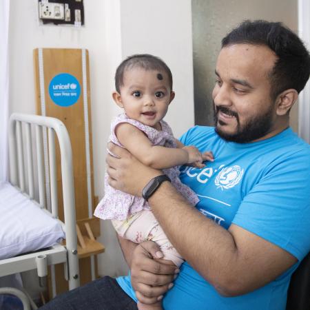 Le conseiller de l’UNICEF, Anindya Shubhra Banerjee, joue avec une petite fille à la garderie de la clinique Alo. Le 13 février 2023, Shyampur.