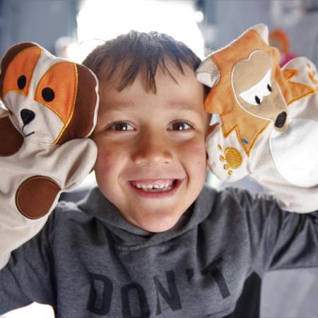 A little boy playing with puppets at a Child Friendly Space in a temporary shelter in Hatay, Türkiye, after two devastating earthquakes hit south-east Türkiye. [© UNICEF/UN0826735/Karacan]