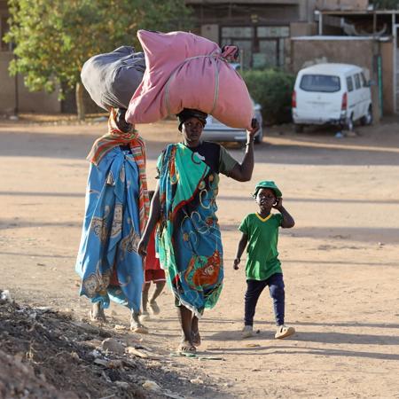 On 19 April 2023, people flee their neighbourhoods amid fighting between the army and paramilitaries in Khartoum, Sudan.