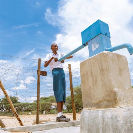 In Turkana, Kenya a young girl uses a handpump for water