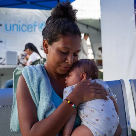 A woman holds a baby at a temporary health clinic. 